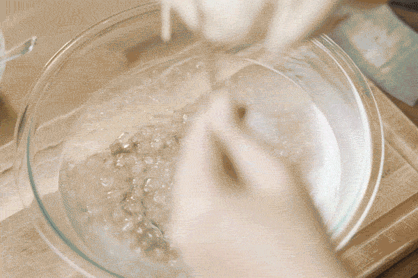 Poached whole chicken is transferred into an ice bath to cool quickly and help the skin set.