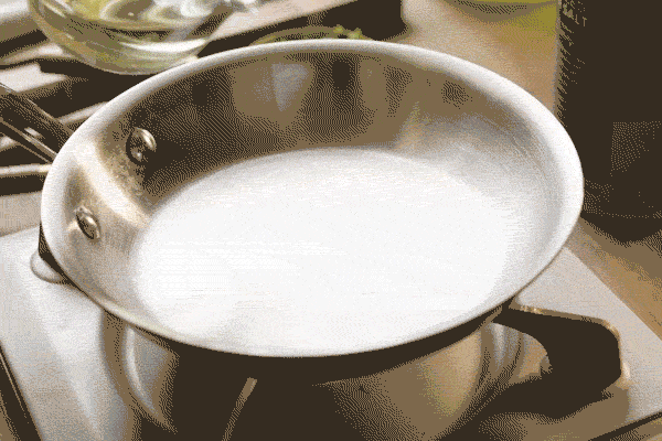 Neutral oil heats in a small saucepan on the stove until shimmering.