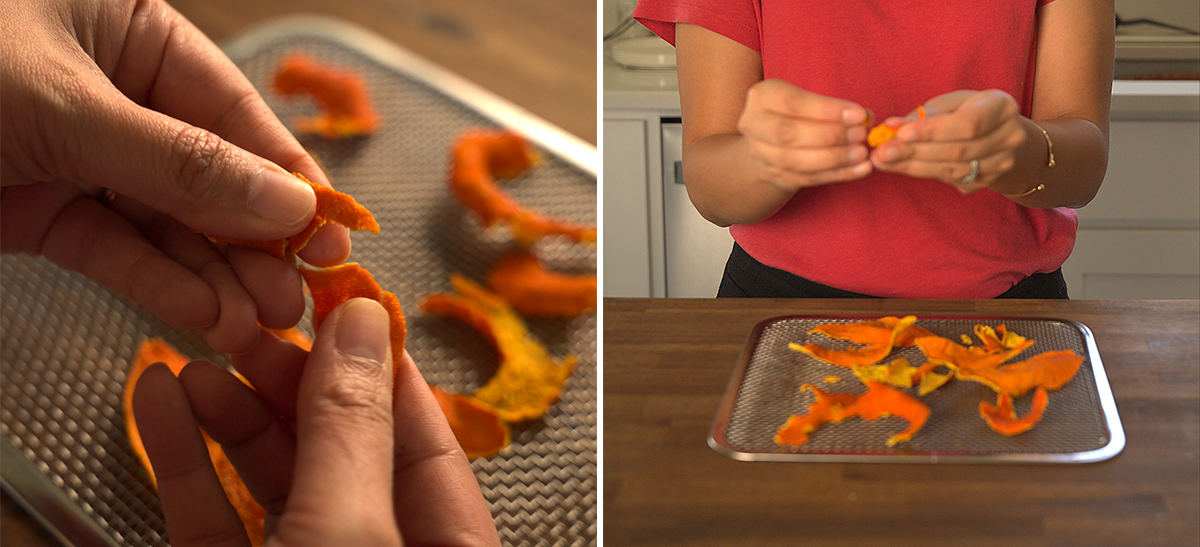 Close-up of hands holding a curled piece of dried orange peel over a mesh dehydrator tray with more dried peels scattered around. Right: Person in a red shirt breaking apart a piece of dried orange peel over a mesh tray on a wooden table.