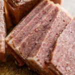 Close-up of homemade SPAM slices showing the firm cured texture and slight marbling from pork shoulder and ham