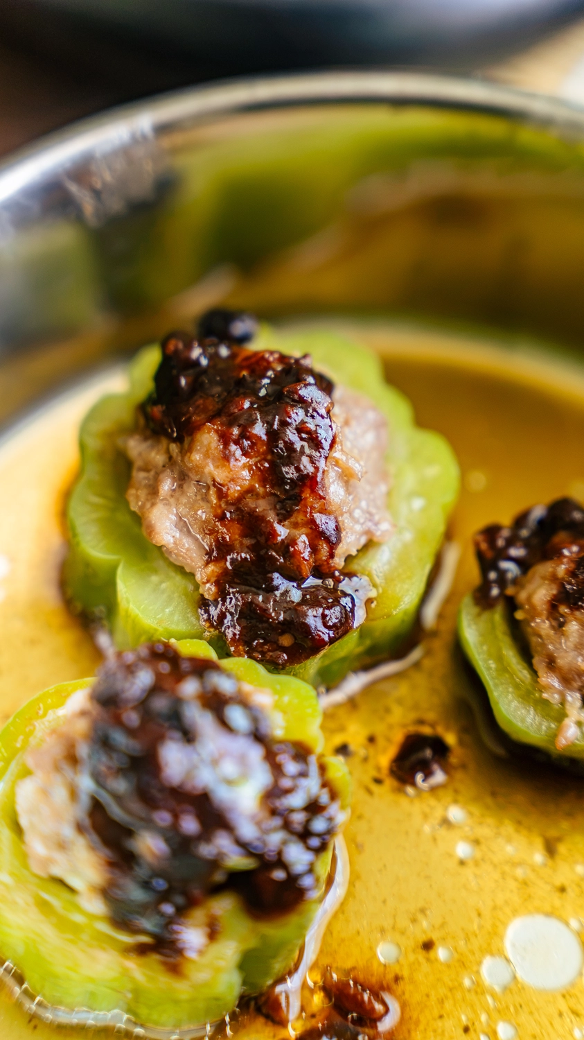 Close-up of stuffed bitter melon rings topped with garlic black bean sauce