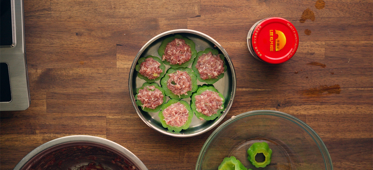 Bitter melon rings stuffed with raw pork hash filling arranged in a steamer tray